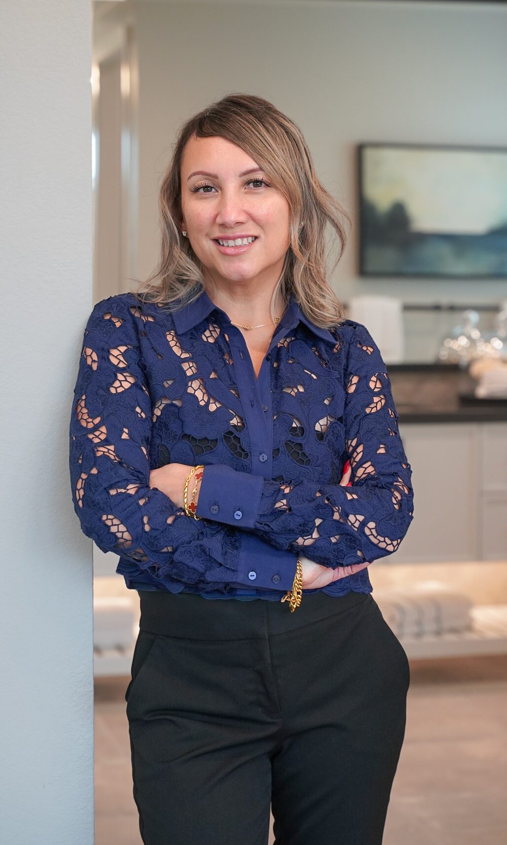 Jenn Pagsolingan in a navy lace blouse, leaning against a wall